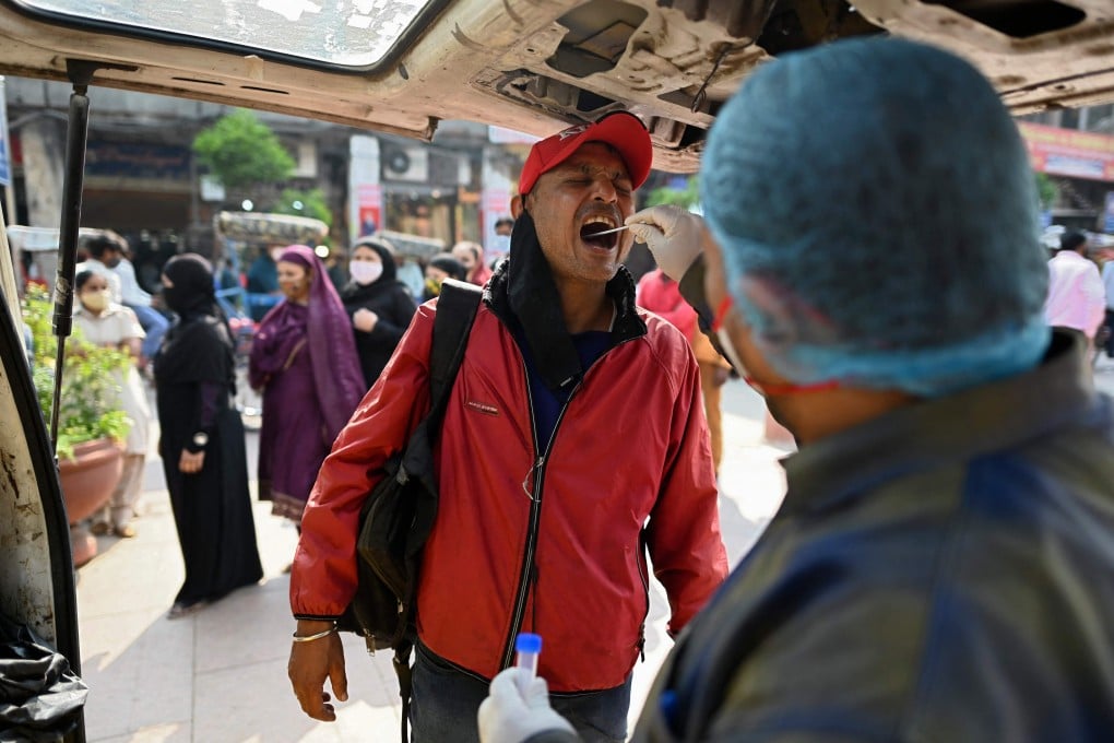 A health worker takes a swab sample from a man for a coronavirus test in Delhi on Tuesday. Photo: AFP