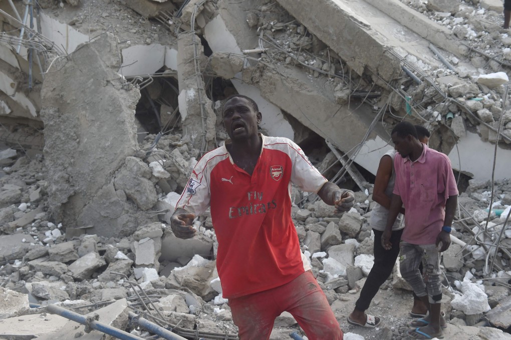 A man standing in the rubble of a 21-storey building under construction that collapsed in Lagos on November 1. Photo: AFP