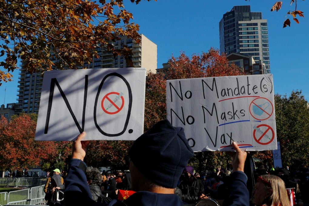A demonstrator holds signs opposing mandates for the coronavirus vaccine in Boston, Massachusetts, US on Sunday. Photo: Reuters