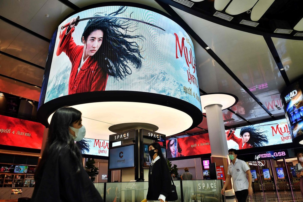 People walk past advertising displays at a cinema inside a shopping centre in Bangkok. Photo: AFP