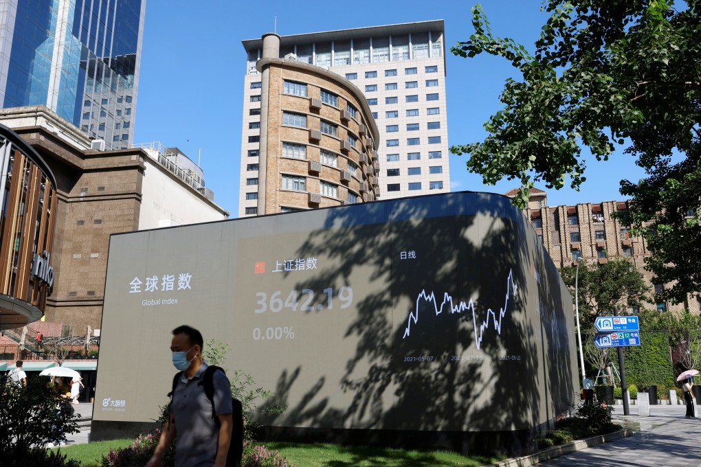 A man walks by an electronic display showing stock index levels in Shanghai on September 24, 2021. Photo: Reuters