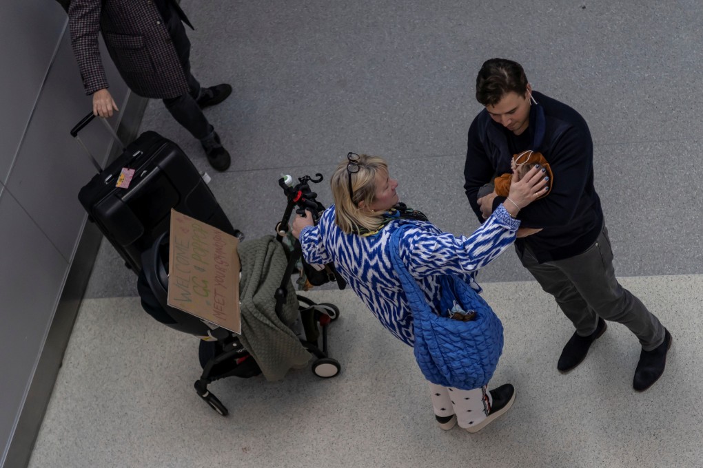 Jill Brownbill caresses her newly born grandson Rocco on November 8 while arriving at New York’s John F. Kennedy International Airport. The US has reopened land borders for the first time since Covid-19 restrictions were imposed. Photo: Reuters