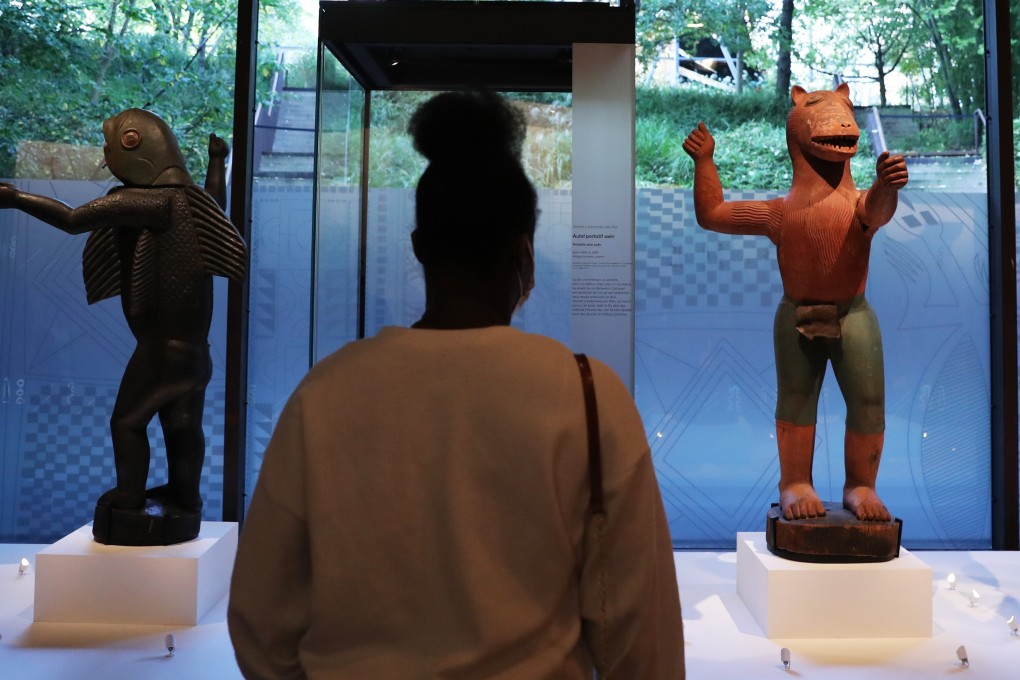 A woman views artefacts at the at the Quai Branly Museum that will be returned to Benin. Photo: Xinhua