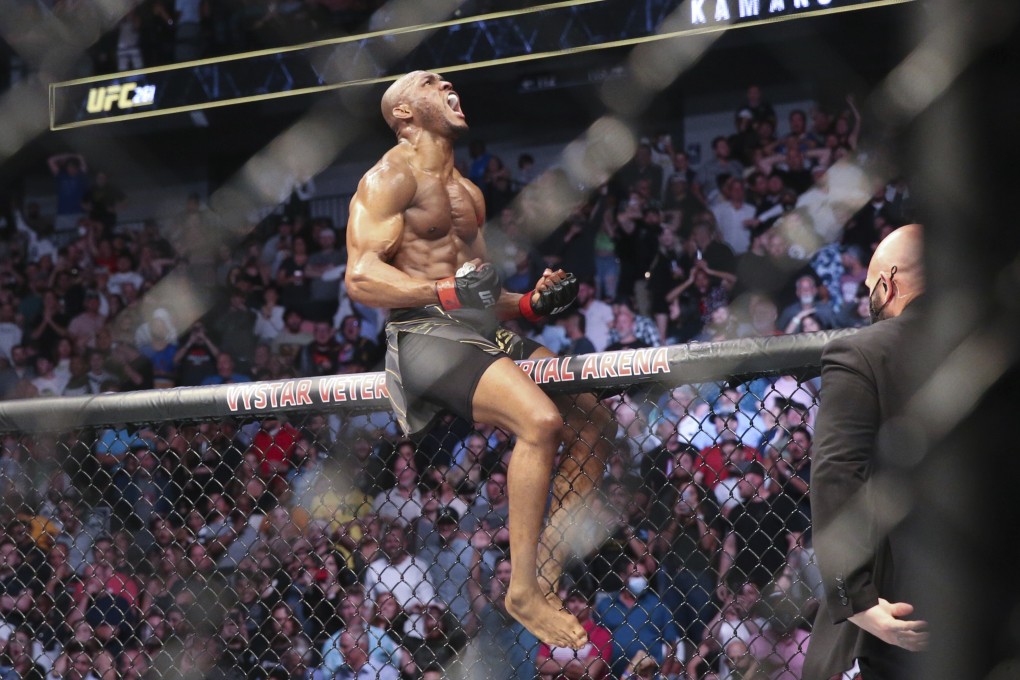 Kamaru Usman celebrates his win atop the octagon fence after a UFC 261 mixed martial arts bout against Jorge Masvidal in April, 2021. Photo: AP
