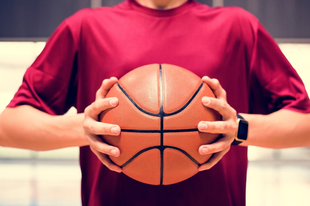 A teenager holding a basketball on the court. Photo: Shutterstock