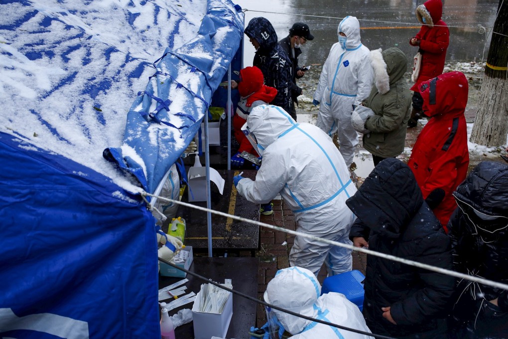 People line up for nucleic acid testing in the snow at a testing site in Jinpu new area in Dalian. Photo: Reuters