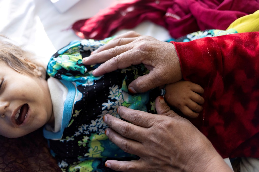 A woman comforts a crying child on the malnutrition ward in a hospital in Kabul, Afghanistan. Photo: Reuters