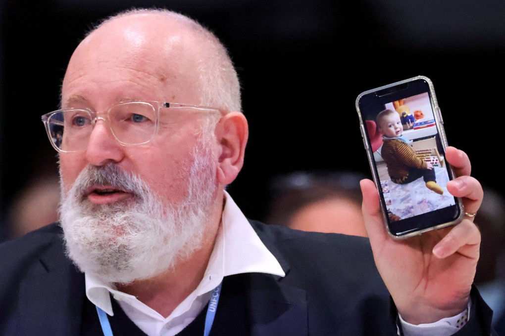 The EU’s climate policy chief Frans Timmermans shows a picture of his one-year-old grandson as he speaks at the COP26 conference in Glasgow on November 12. He said: “If we fail he will fight with other human beings for water and food. That’s the stark reality we face.” Photo: Reuters