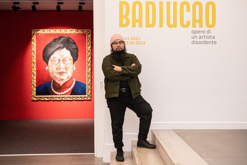 Chinese dissident artist Badiucao poses next to his artwork entitled ‘Carrie Lam, 2018’ at the opening of his exhibition in Brescia, Italy. Photo: AFP