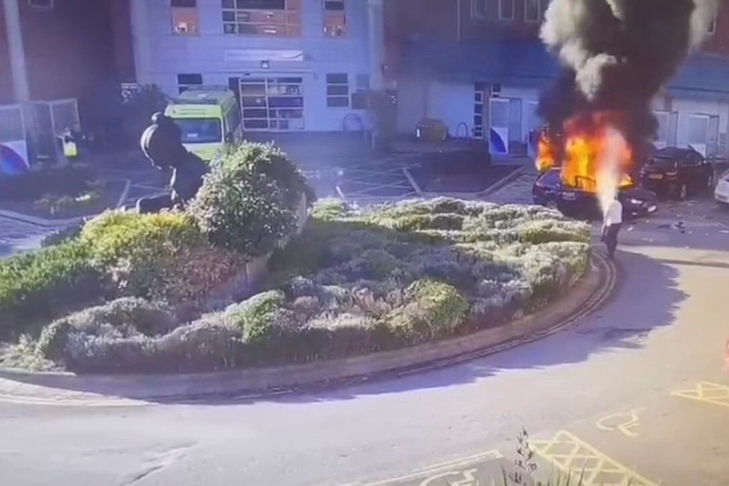 Surveillance camera footage shows a man extinguishing a burning taxi following an explosion outside Liverpool Women's Hospital in Britain on November 14. Photo via Reuters