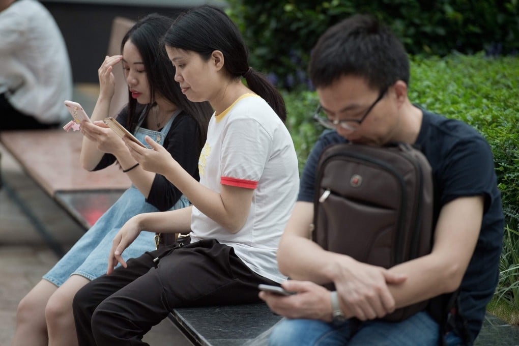People use smartphones in Shenzhen, China. A new regulation proposed by the Cyberspace Administration of China would punish individuals and organisations for providing tools and services for others to access censored foreign websites. Photo: AFP Photo
