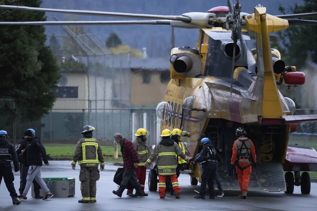 Search and rescue personnel help flood evacuees disembark from a helicopter in Agassiz, British Columbia. Photo: AP