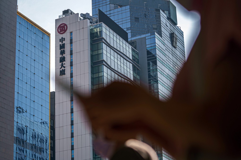 A pedestrian walks past the China Huarong Tower, which houses the headquarters of China Huarong International Holdings Ltd., a unit of China Huarong Asset Management Co., centre, in Hong Kong, China, on Tuesday, April 13, 2021. Photo: Bloomberg