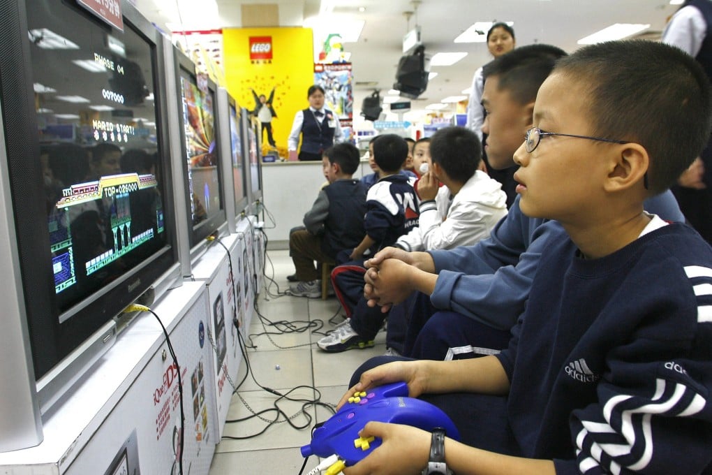 Children play the video games on TVs at a shopping centre in Chengdu, in China's southwestern Sichuan province, on October 30, 2006. The Chinese government has long had an uncomfortable relationship with video games, and it ramped up restrictions for minors again this year. Photo: AFP