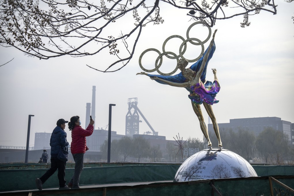 Visitors take photos of a statue of figure skaters with the Olympic rings in Beijing, on November 18. Photo: AP