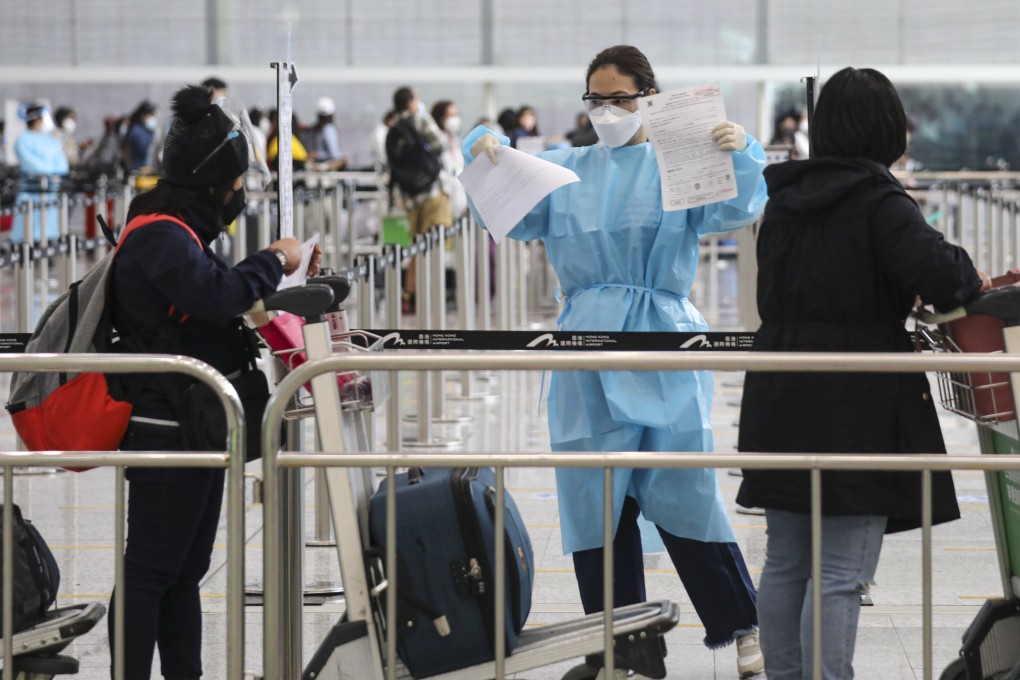 A worker ensures arrivals have the necessary health documents at Hong Kong International Airport. Xiaomei Chen