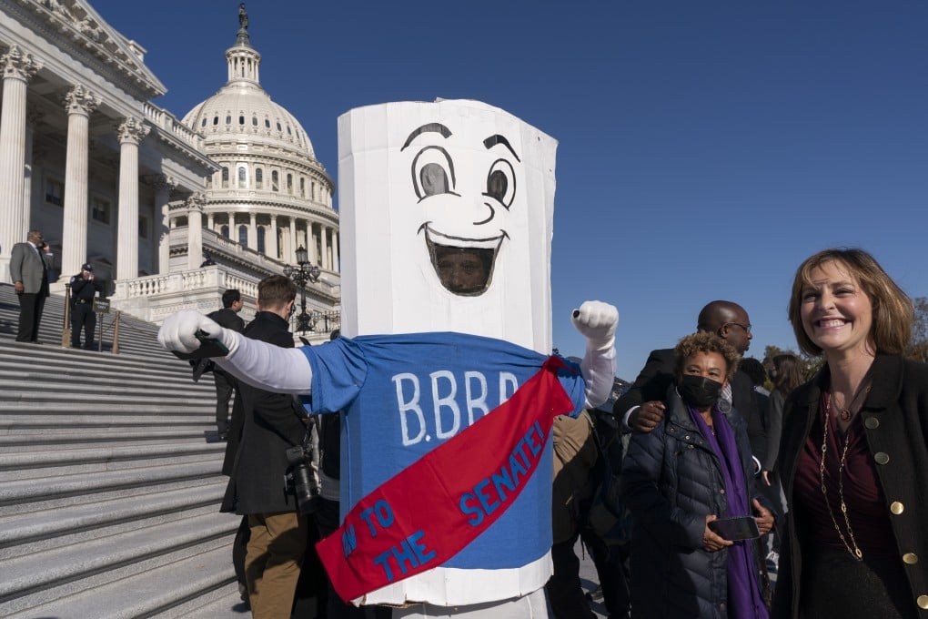 A man dressed as the Build Back Better Bill wears a sash saying “on to the Senate” as members of the US House leave after the vote on Capitol Hill on Friday. Photo: AP
