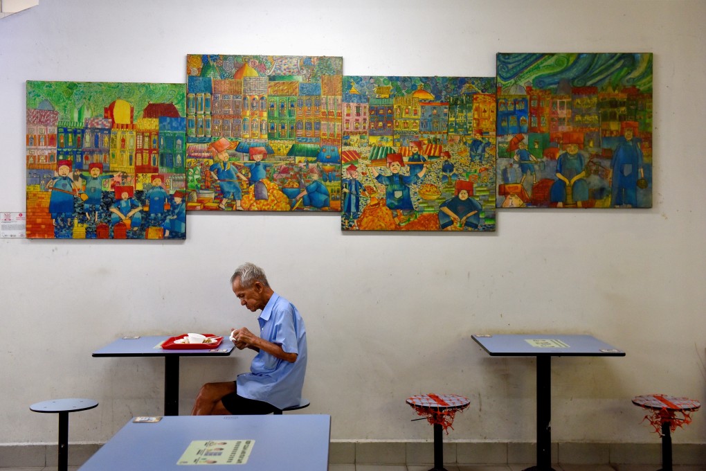 A man dines alone in a food centre in Singapore. From Monday, dining out in groups of up to five people will be allowed. Photo: Reuters