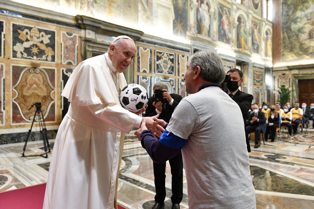 Pope Francis is presented with a football during an audience with members of the team of the World Rom Organisation and the ‘Pope’s Team – Fratelli tutti’ at The Vatican on Saturday. Photo: Vatican Media / AFP