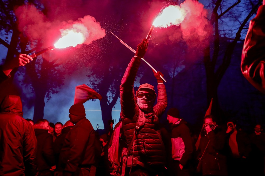 People burn bengalos as they take part in a demonstration against coronavirus restrictions in Vienna, Austria on Saturday. Photo: AP