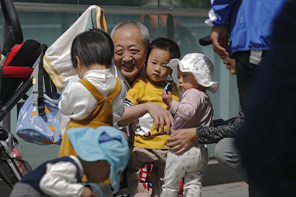 An elderly man plays with children in Beijing on May 10, 2021. This year, for the first time, China will officially have more deaths than births. Photo: AP
