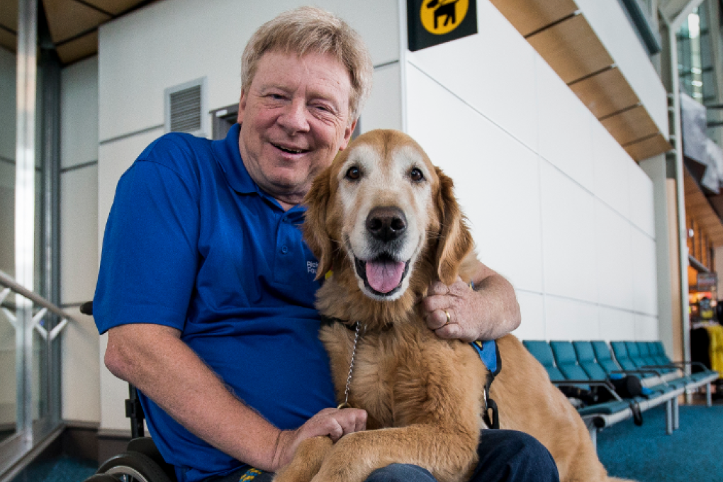 Brad McCannell, who is vice-president of access and inclusion with the Rick Hansen Foundation cuddles with his dog. Photo: YVR