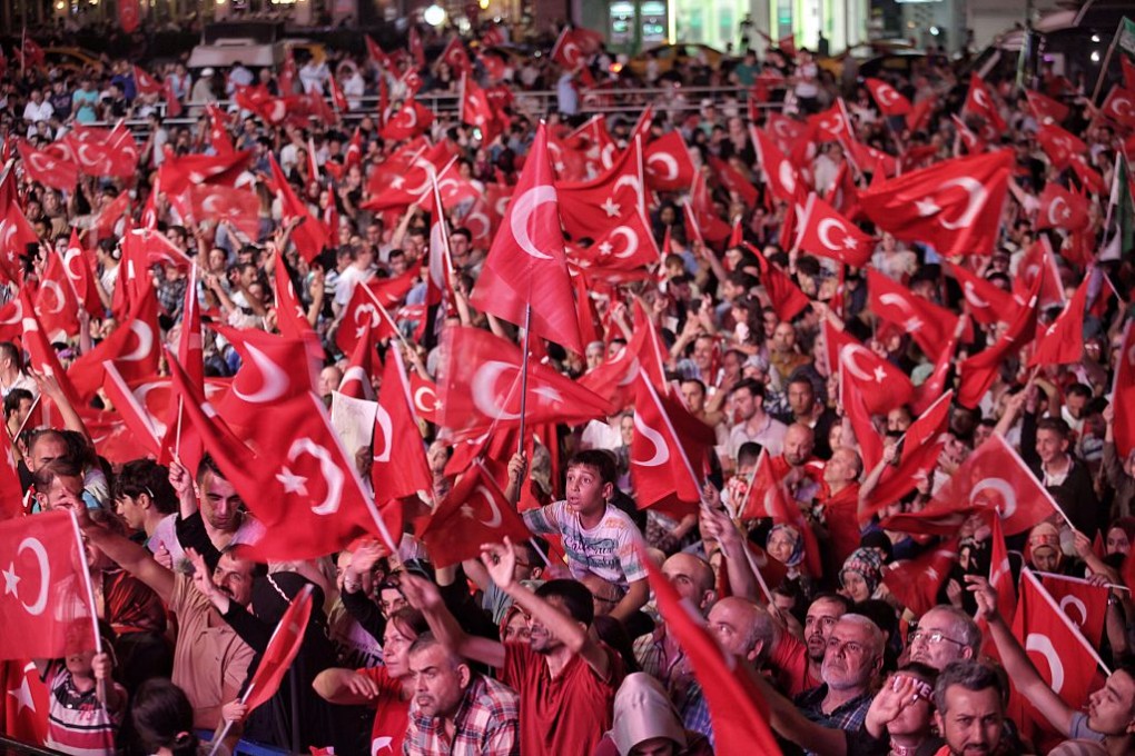 Supporters of Turkish President Tayyip Erdogan wave Turkish flags as they gather in Istanbul's central Taksim Square in Istanbul, Turkey. Photo: Kursat Bayhan/Getty Images