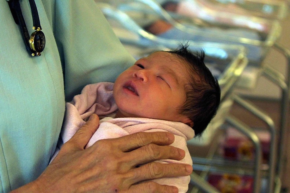 A nurse holds a newborn baby at the labour ward of Singapore's Kandang Kerbau Hospital (KKH). Photo: Angie Chan/AFP/Getty Images