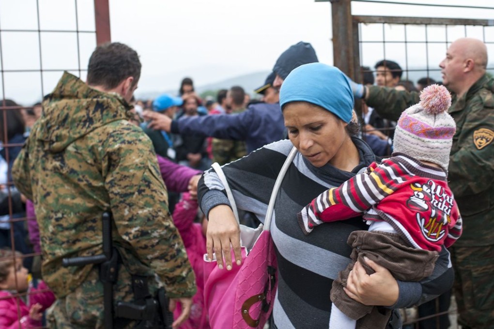 Macedonian police officers control a crowd of migrants and refugees as they prepare to enter a camp after crossing the Greek border into Macedonia near Gevgelija on October 8, 2015. Photo: AFP