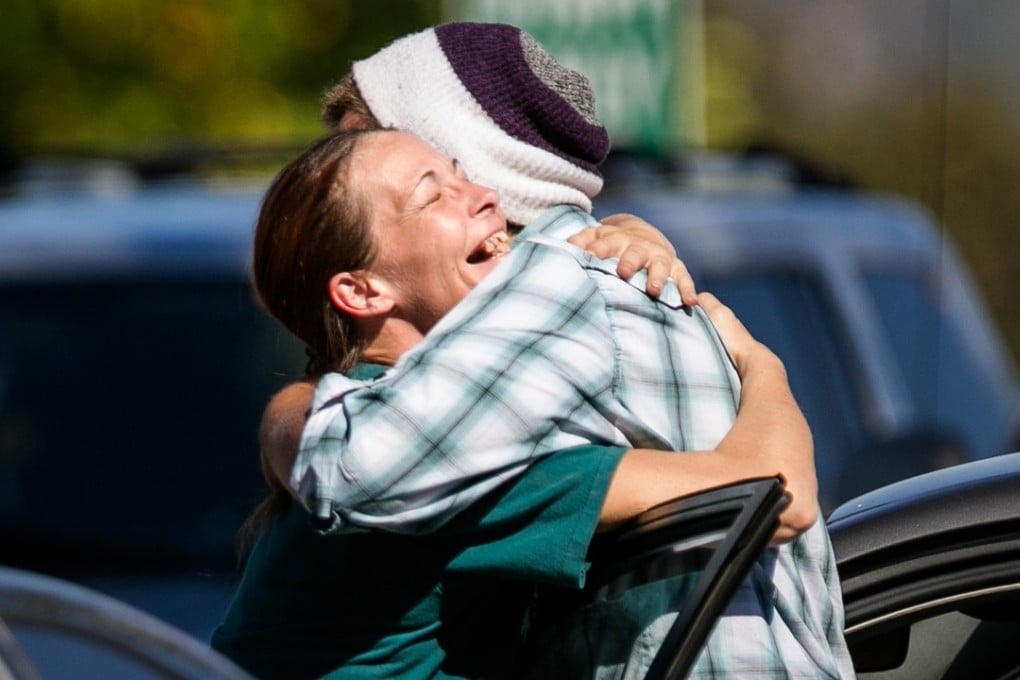 Mathew Downing, right, the "lucky survivor" of the Umpqua Community College mass shooting, hugs a friend as he arrives back on campus when it reopened last week. Photo: TNS