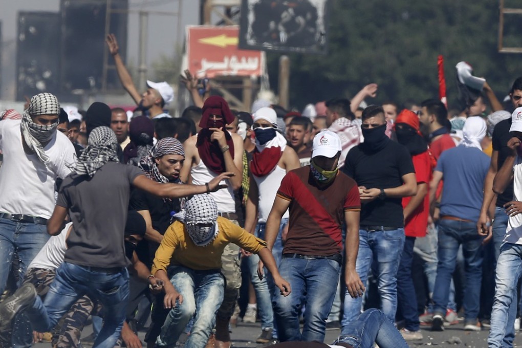 An injured Palestinian demonstrator is helped during clashes at the Hawara checkpoint near of the West Bank city of Nablus. Photo: AP