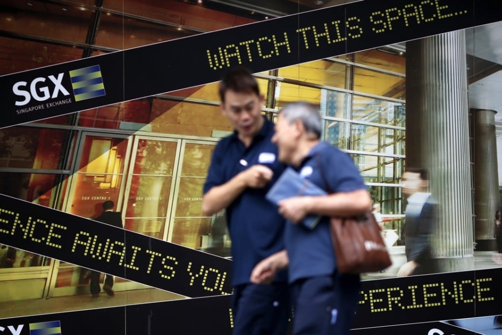 People walk past a logo of the Singapore Stock Exchange (SGX) outside its premises in the city state’s financial district. Photo: Reuters