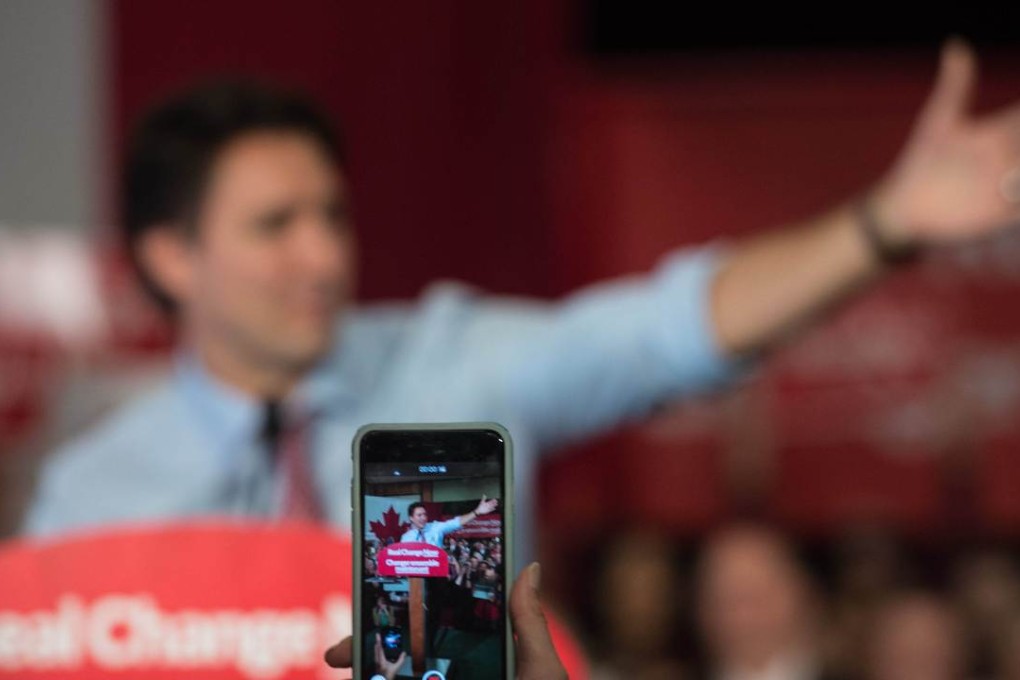 A supporter of Canadian Liberal Party leader Justin Trudeau films him on her smartphone as he speaks at a victory rally in Ottawa. Photo: AFP