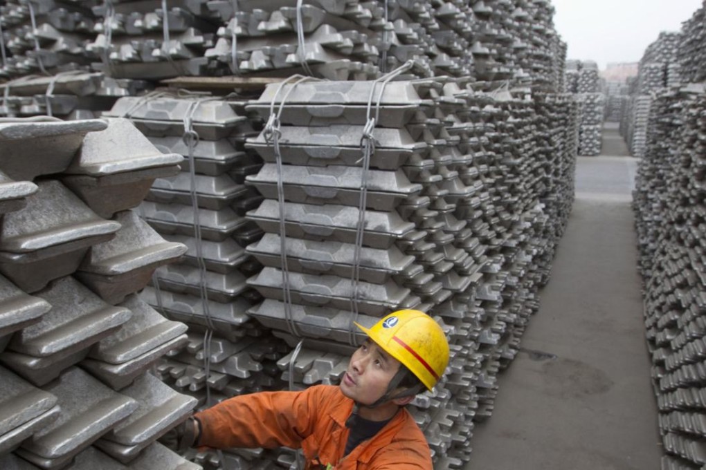An employee checks aluminium ingots at Qingdao port in China. Photo: Reuters
