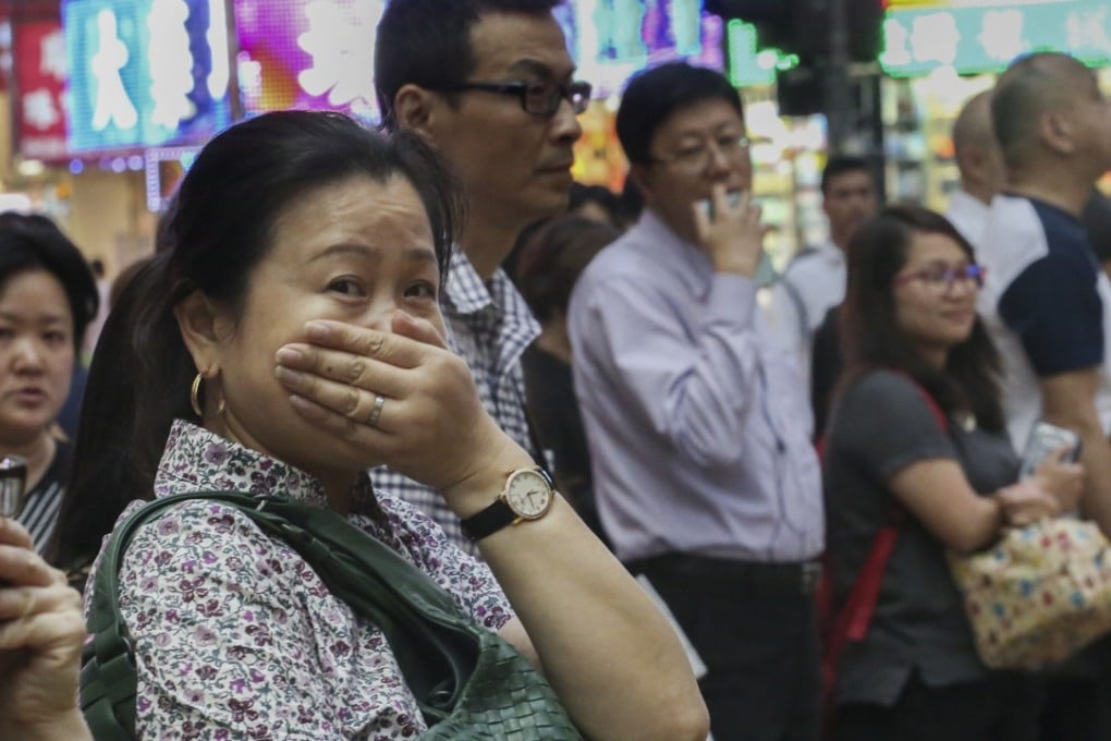 Pedestrians cover their mouths on the street in Causeway Bay in Hong Kong. Roadside Air Quality Health Index hit unhealthy levels when a typhoon swirled near the congested territory. Photo: Felix Wong