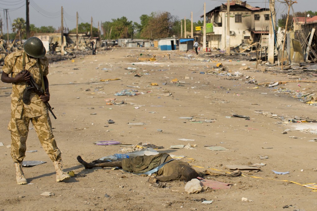 In this 2014 file photo, a South Sudanese government soldier inspects the body of a dead woman lying in the street in Bor, Jonglei State, South Sudan. Photo: AP
