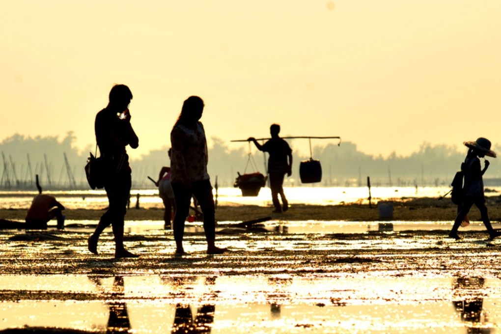 Fishermen walk on a beach in Beihai on October 17. China's port city of Beihai, historically a major trade hub for the country's southwest, has been the fastest-growing city in Guangxi in recent years. Photo: Xinhua