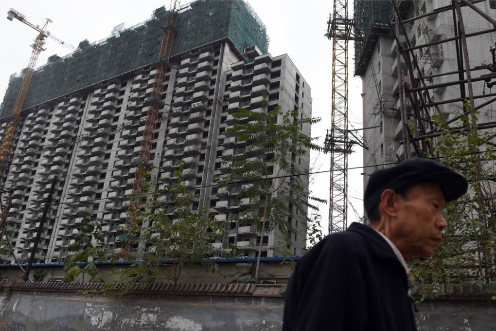 A man walks past a construction site for apartment buildings in Beijing. Photo: AFP