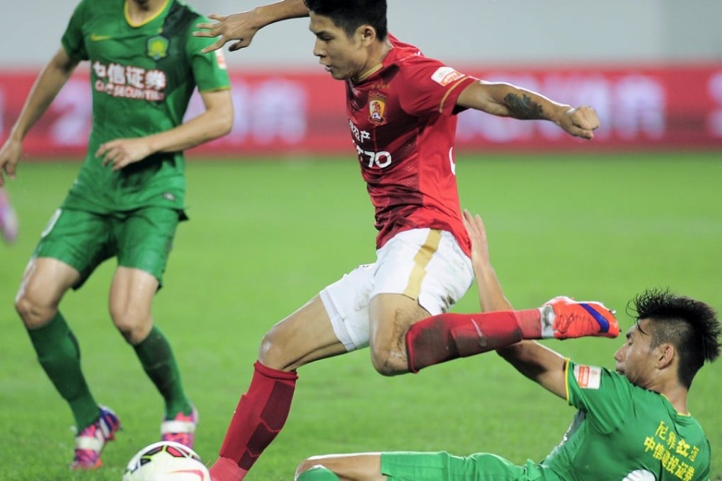Guangzhou Evergrande Taobao (in red) play against Beijing Guoan during a soccer match in Guangzhou earlier this year. The real estate group won approval to list the club on China’s over the counter securities market for small companies. Photo: Reuters