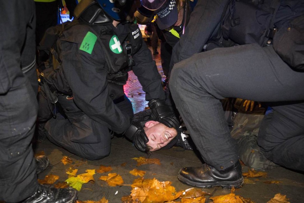 British police officers pin a protester to the ground in Trafalgar Square in London on Thursday night. Photo: AFP