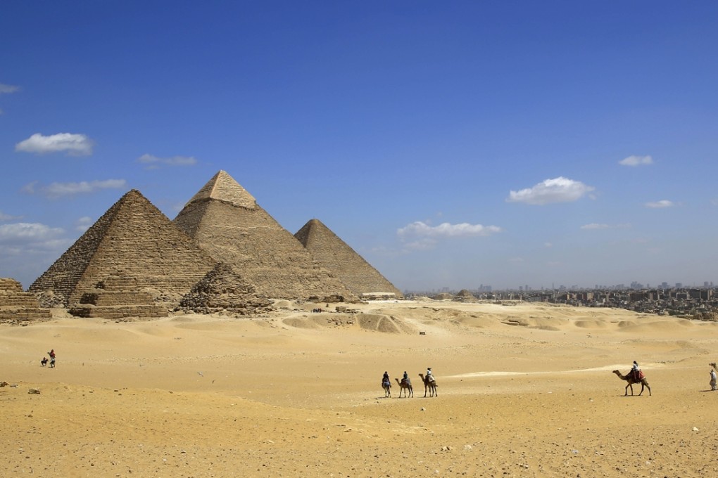 Tourists ride camels at the historical site of the Giza Pyramids in Giza, near Cairo, Egypt. Photo: AP