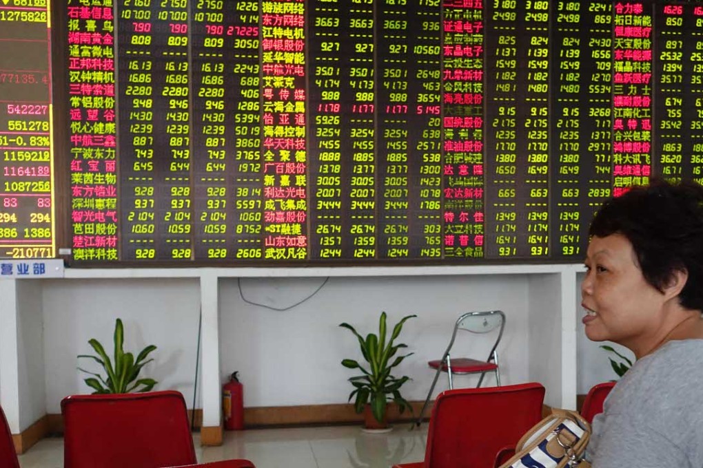 An investor looks through stock information at a trading hall in a securities firm in Haikou, capital of south China's Hainan Province, on October 21.