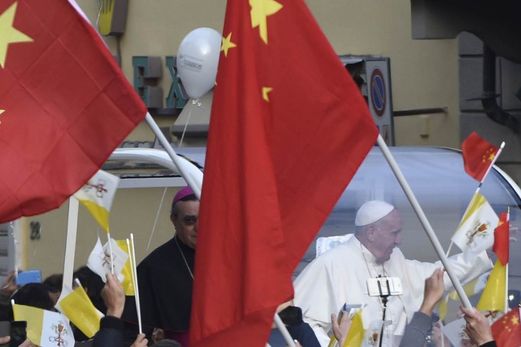 People wave Chinese flags and Vatican flags as Pope Francis waves to the crowd in a street in Prato. Photo: AFP