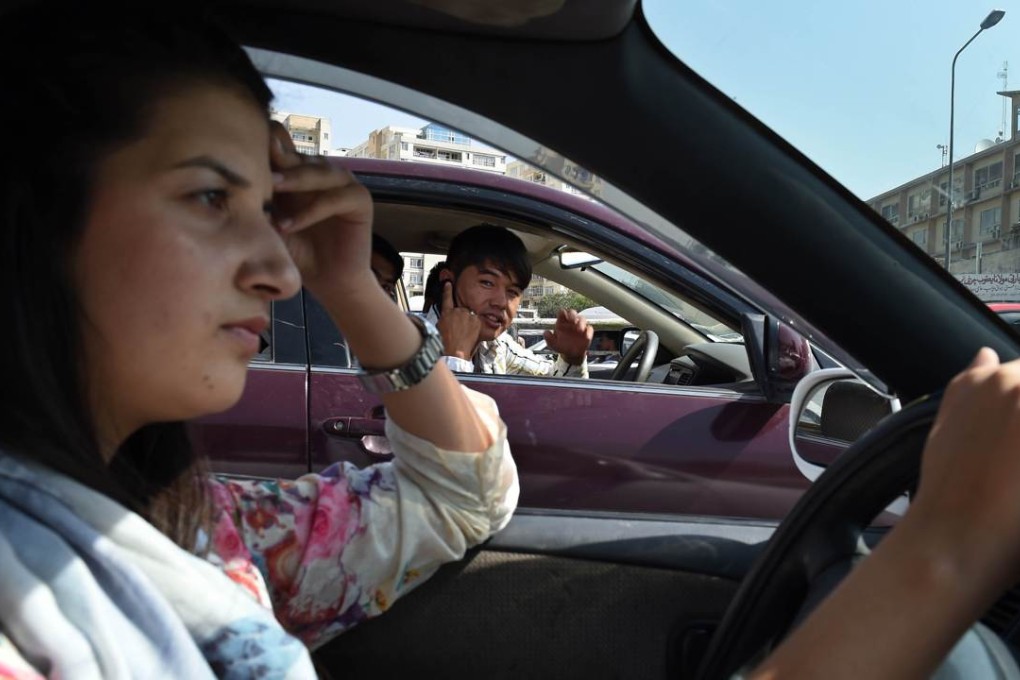 Afghan woman Rokhsar Azamee, 23, faces abuse from a male motorist as she drives her car in Kabul. Photos: AFP