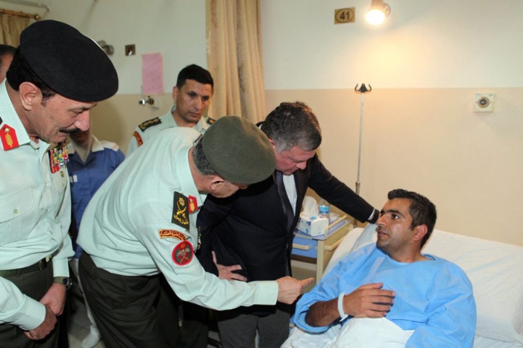 Jordan’s King Abdullah II, (in suit jacket) visits the injured victims of a shooting spree in Amman on Monday. Photo: EPA