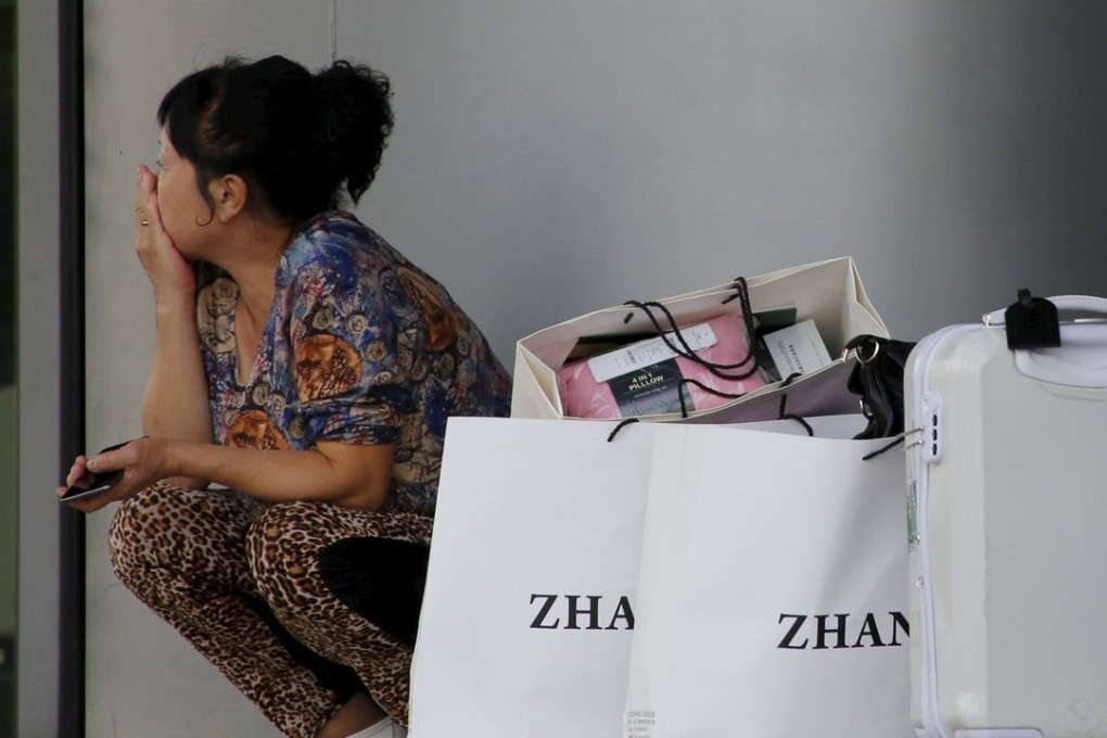 A woman sits next to her shopping bags near a shopping mall in Beijing. Mainland bank card consumer transactions rose 33 per cent last year to 42.38 trillion yuan. Photo: Reuters