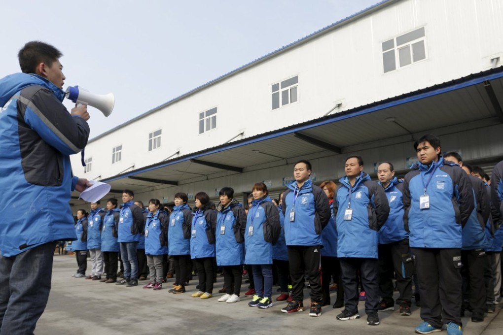 Workers listen to their line manager as he prepares them for the upcoming Singles Day shopping festival, at a sorting centre of Zhongtong (ZTO) Express, Chaoyang District, Beijing. Photo: Reuters