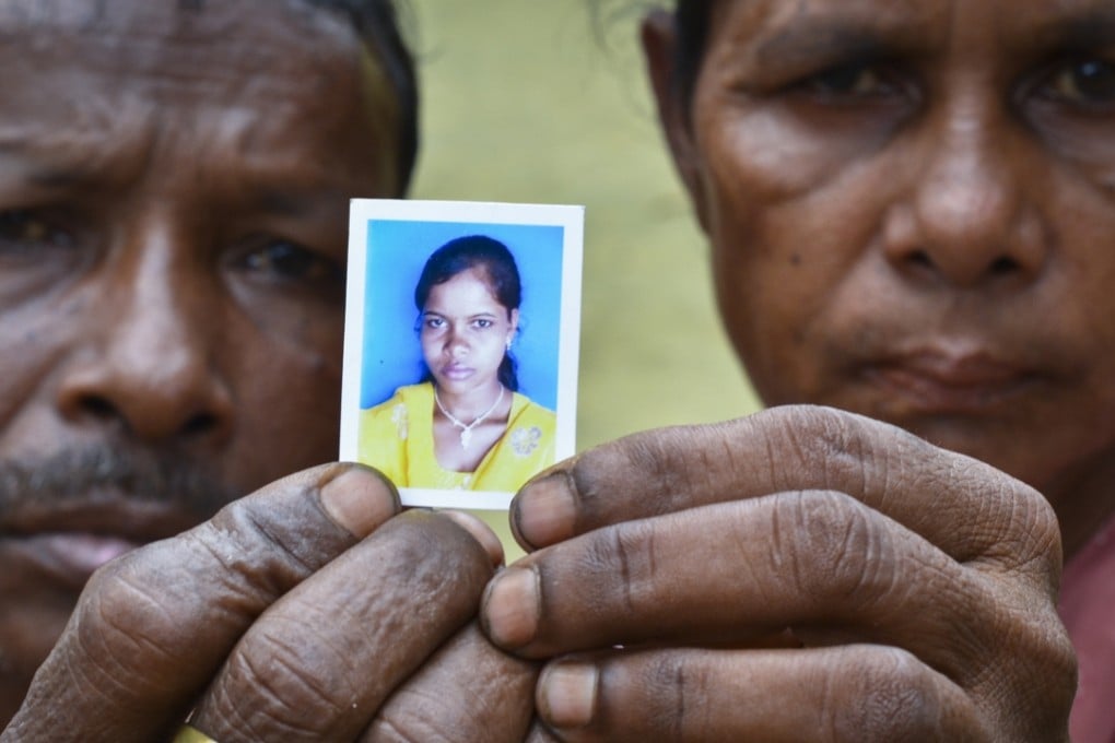 A couple in Assam, India, show a photo of their daughter who was trafficked to Delhi at the age of 14, and whom they had not seen since. Photo: Gethin Chamberlain