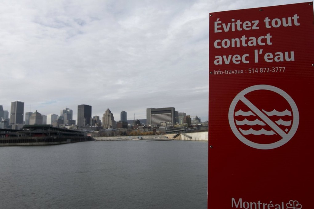 A sign reading “don't touch the water” is posted near the St Lawrence river in front of the city of Montreal which began dumping raw sewage into the river on Wednesday. Photo: Reuters