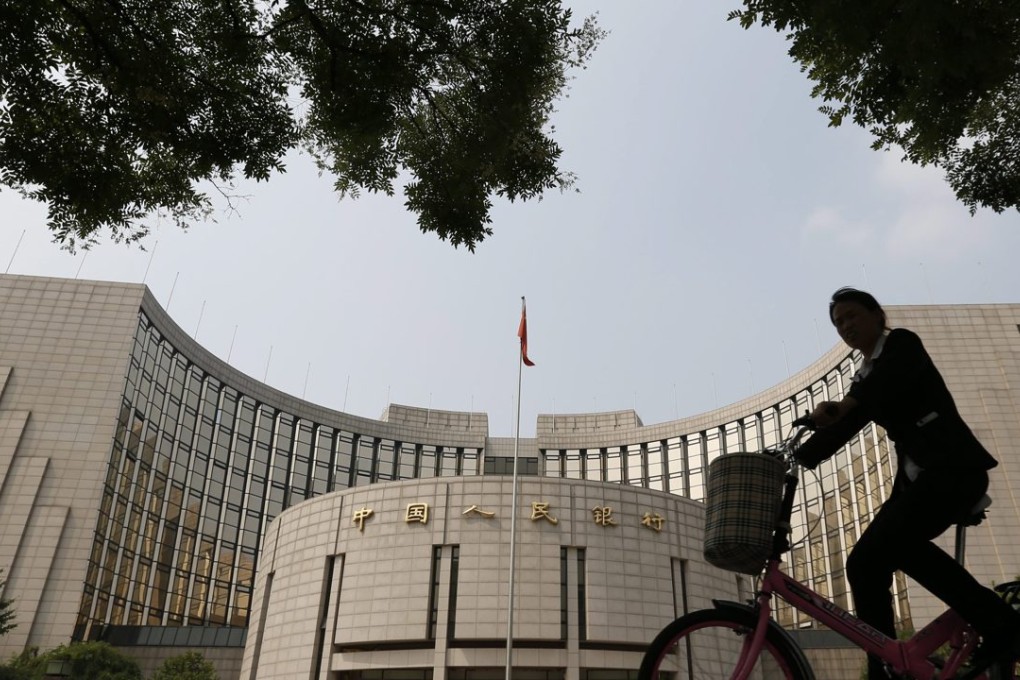 A cyclist passes in front of the People's Bank Of China building in Beijing, China. Photo: EPA